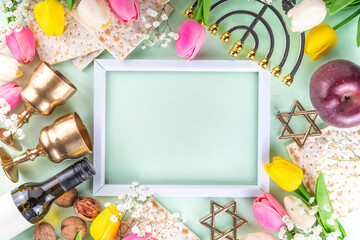 Passover, Pesah background. jewish Easter Passover spring holiday celebration, with accessories - menorah, matzo, spring flowers, wine bottle, gold wine glass, jewish david stars, copy space top view 