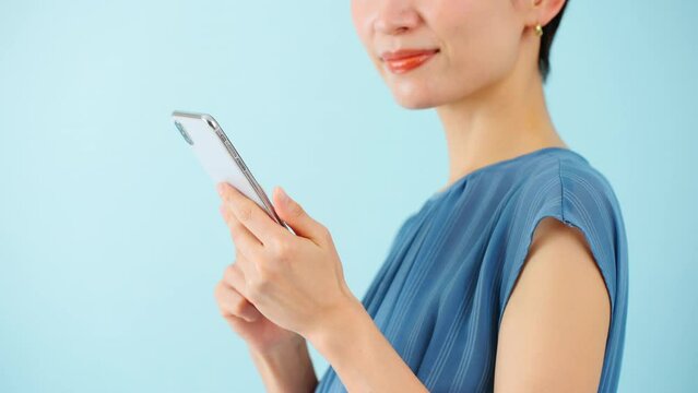 スマートフォンを使うワンピースを着た若い女性	