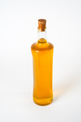 Olive oil in a glass bottle with a cork stopper isolated on white background.