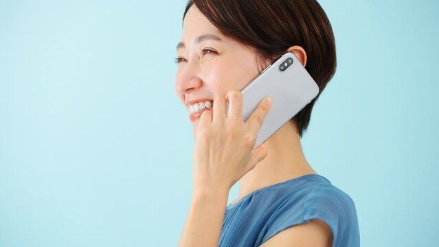 スマートフォンで通話をするワンピースを着た若い女性	