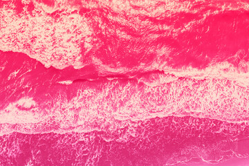 Seascape view from above. Sea surf in viva magenta trendy color toning