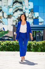 Happy beautiful brunette woman in blue suit