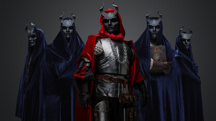 Portrait of four followers and their leader of dark cult dressed in dark robes.