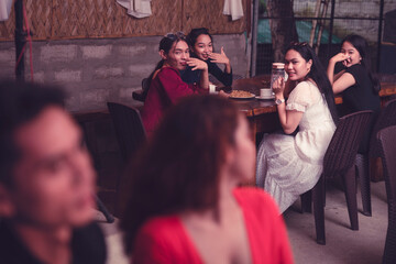 A group of friends obviously gossips about the hetero couple in front of them. Four friends...