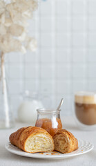 croissant with pear jam for the breakfast with a cup of coffee with milk. French breakfast