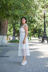 portrait of a young beautiful brunette woman in white dress