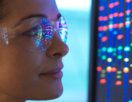 Close-up of scientist with DNA sequencing reflected in eyeglasses