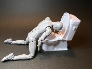 具合が悪くなり、トイレで嘔吐する人形