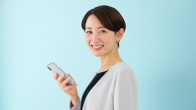 スマートフォンを使う若い女性　ビジネスイメージ	