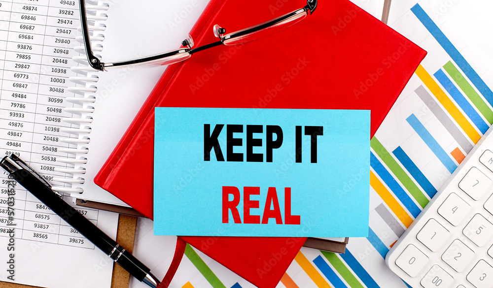 Poster keep it real text on sticky on red notebook on chart background