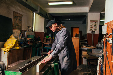 Fototapeta premium Work on woodworking machines and saws in a furniture workshop