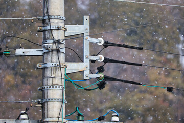 雪が降っている日の電柱と電線