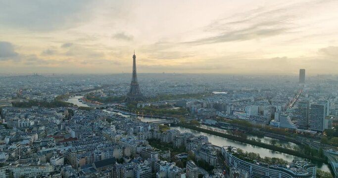 Beautiful view of famous Eiffel Tower in France with magical morning cloud and fog. Wide establishing aerial drone fly over seine river in paris city center, best travel destination landmark in Europe