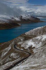Road and blue river in snow mountains