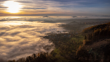Beautiful sunset with an inversion that looks like a flowing sea. Colorful trees in autumn. Sunset under Jested. Photographed by drone