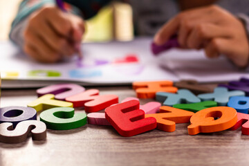 English alphabet made of square wooden tiles with the English alphabet scattered on hand. The concept of thinking development, grammar