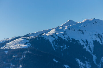 Fototapeta na wymiar Bright sunlight over snow covered mountains in the Austrian Alps - Ski resort Ktizbühel, Tirol 