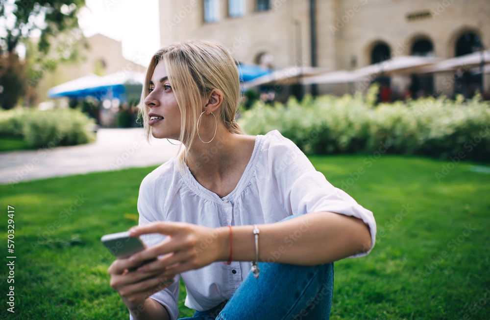 Poster contemplative travel blogger with cellular device thoughtful looking away during free time in summer