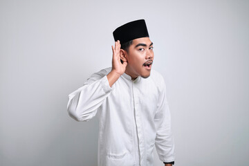 Asian muslim man wearing white clothes trying to listening a gossip