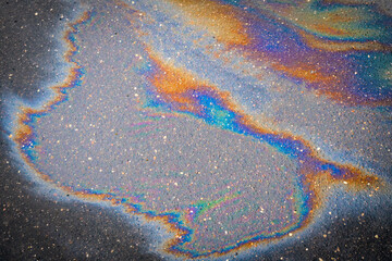 Obraz premium Colored texture of oil products on the asphalt in the rain.
