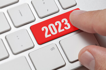 2023 new year, male hand presses red enter key on computer keyboard. New year, happy, startup and Christmas concept. flat design.