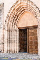  front view, medium distance of the front entrance, double wood doors, of a 1300's century cathedral