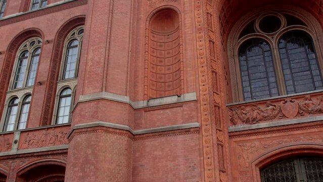 Facade red brick building. Camera movement. Arch deep into the wall, window opening, glass ceilings. Architecture of an old building with several floors.