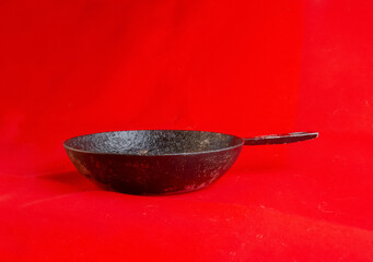 An old cast iron skillet made in circa 1960 against a red background.
