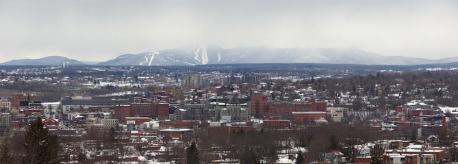Naklejka premium Sherbrooke city in Quebec, Canada. Small city landscape panoramic view downtown winter cityscape mountain