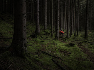 Man with headlamp sitting in dark forest © Mikael