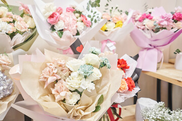 Flower shop concept. Different varieties fresh spring flowers in refrigerator room for flowers. Bouquets on shelf, florist business