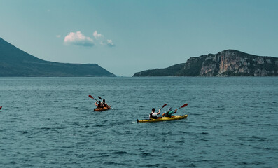 canoe trip in the sea , mountains shore, tourist group making water sports