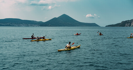 canoe trip in the sea , mountains shore, tourist group making water sports