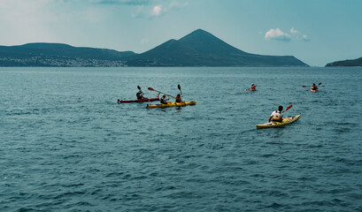 canoe trip in the sea , mountains shore, tourist group making water sports