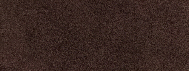 Texture of dark brown velvet matte background, macro. Suede umber fabric with pattern. Textile...