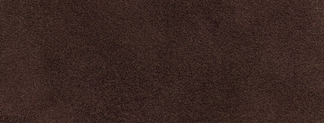 Texture of dark brown velvet matte background, macro. Suede umber fabric with pattern. Textile leather backdrop,