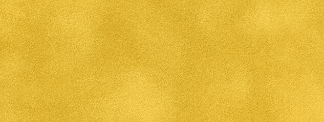 Texture of yellow velvet matte background, macro. Suede golden fabric with pattern. Textile leather backdrop,