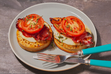 Crumpets with melted cheese,bacon,honey and topped of with tomato.