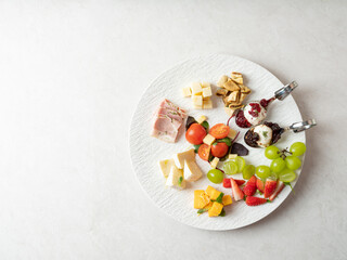 Various cheeses, fruits and raw ham