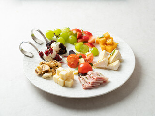 Various cheeses, fruits and raw ham
