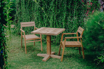 dining table and chairs for outdoor garden from teak wood with plants background