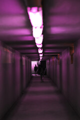 a couple of people walking down the tunnel 