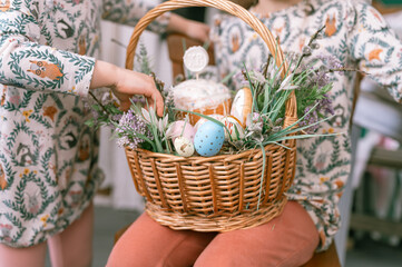 Russia, Moscow, 04.09.2022. happy easter holiday time in spring season. family and little kids sisters holds basket with painted eggs and easter baked cakes. festive home decor. traditional food
