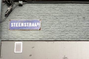 Blue street name sign of Streenstraat on a blue stone wall  in Arnhem in the Netherlands