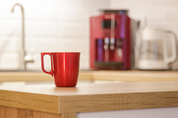 Single red coffee mug on the wooden kitchen countertop