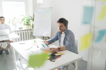 Focused man working on laptop in creative workspace