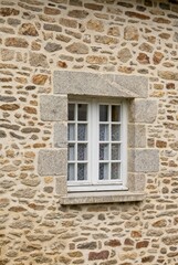 Fototapeta na wymiar Antique casement window set in stone wall granite block quions