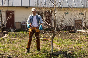 Portrait of young man pruning branch