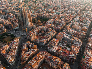 Aerial view of Barcelona City Skyline and Sagrada Familia Cathedral at sunset. Eixample residential...