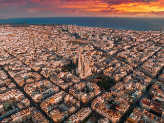 Aerial view of Barcelona City Skyline and Sagrada Familia Cathedral at sunset. Eixample residential...